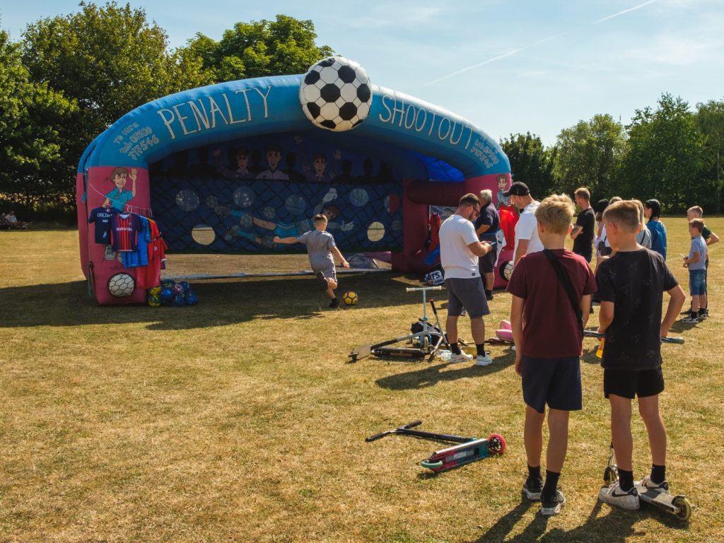 Children line up to play at an inflatable football goal