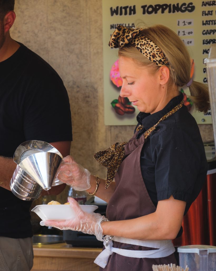 A woman salting a portion of chips ahead of serving them
